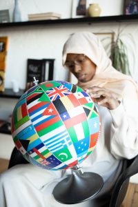A globe with many international flags all over it instead of country borders.