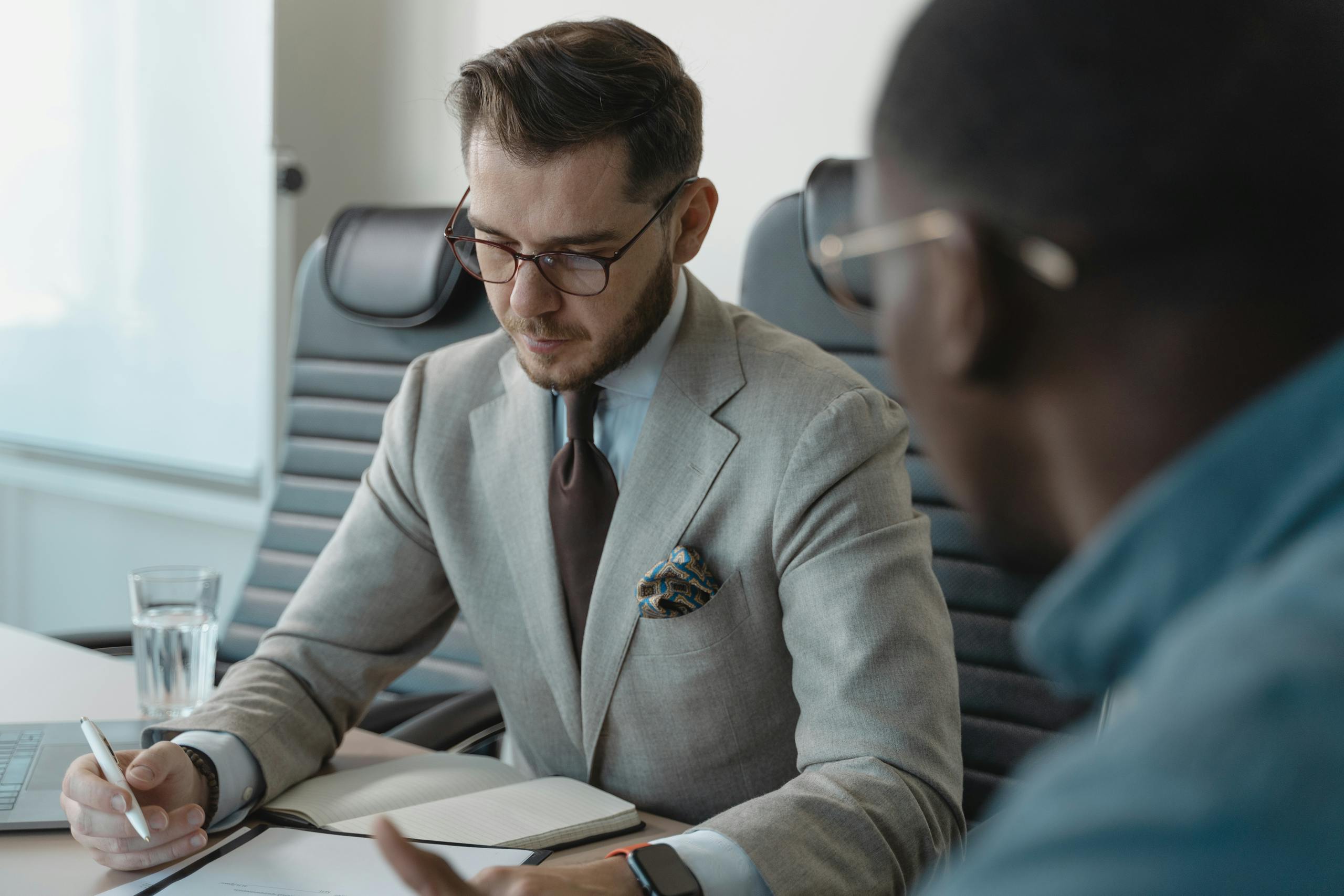 A Instructor reviews feedback documents during a performance review in a modern office setting.