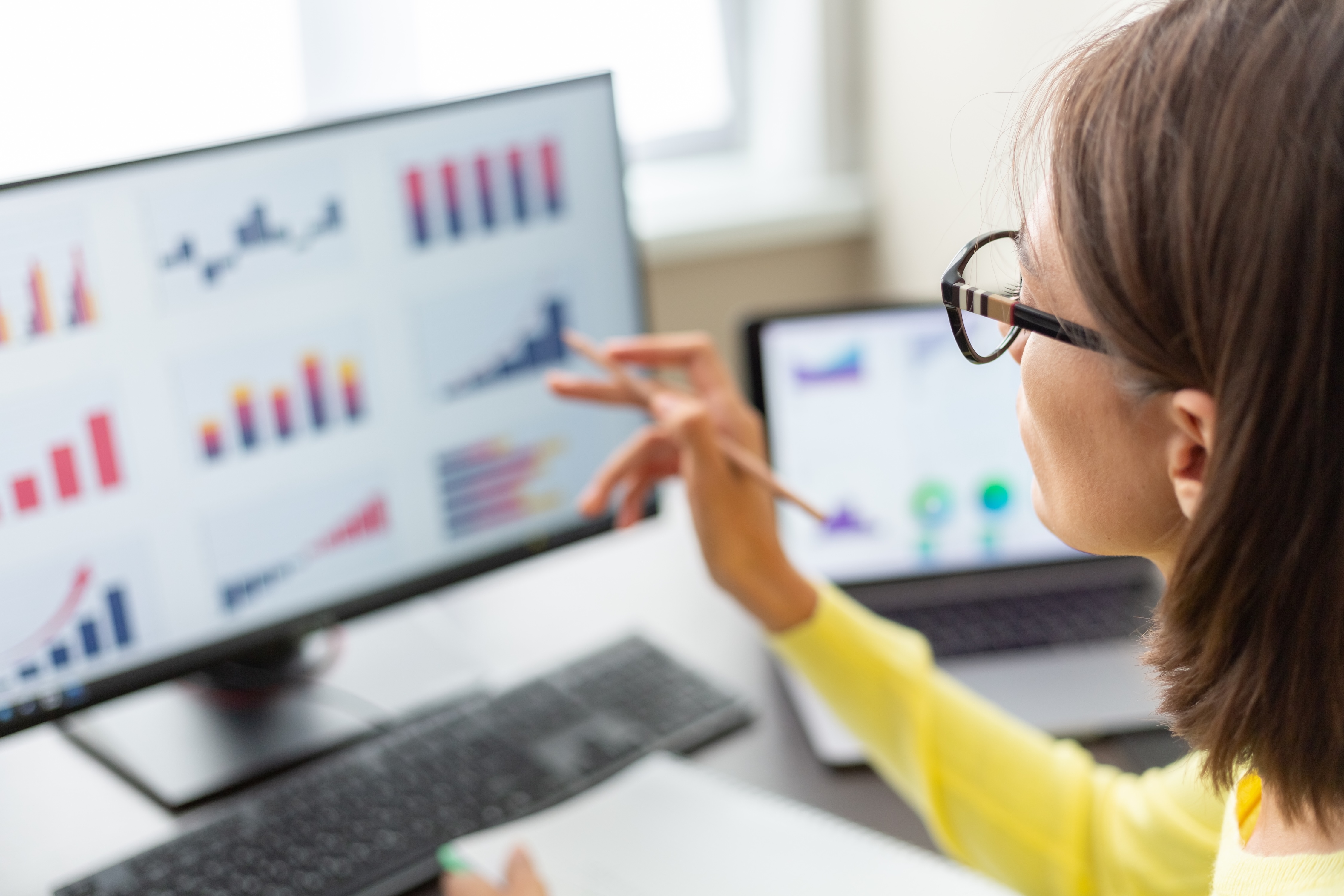 woman looking at data charts on her computer