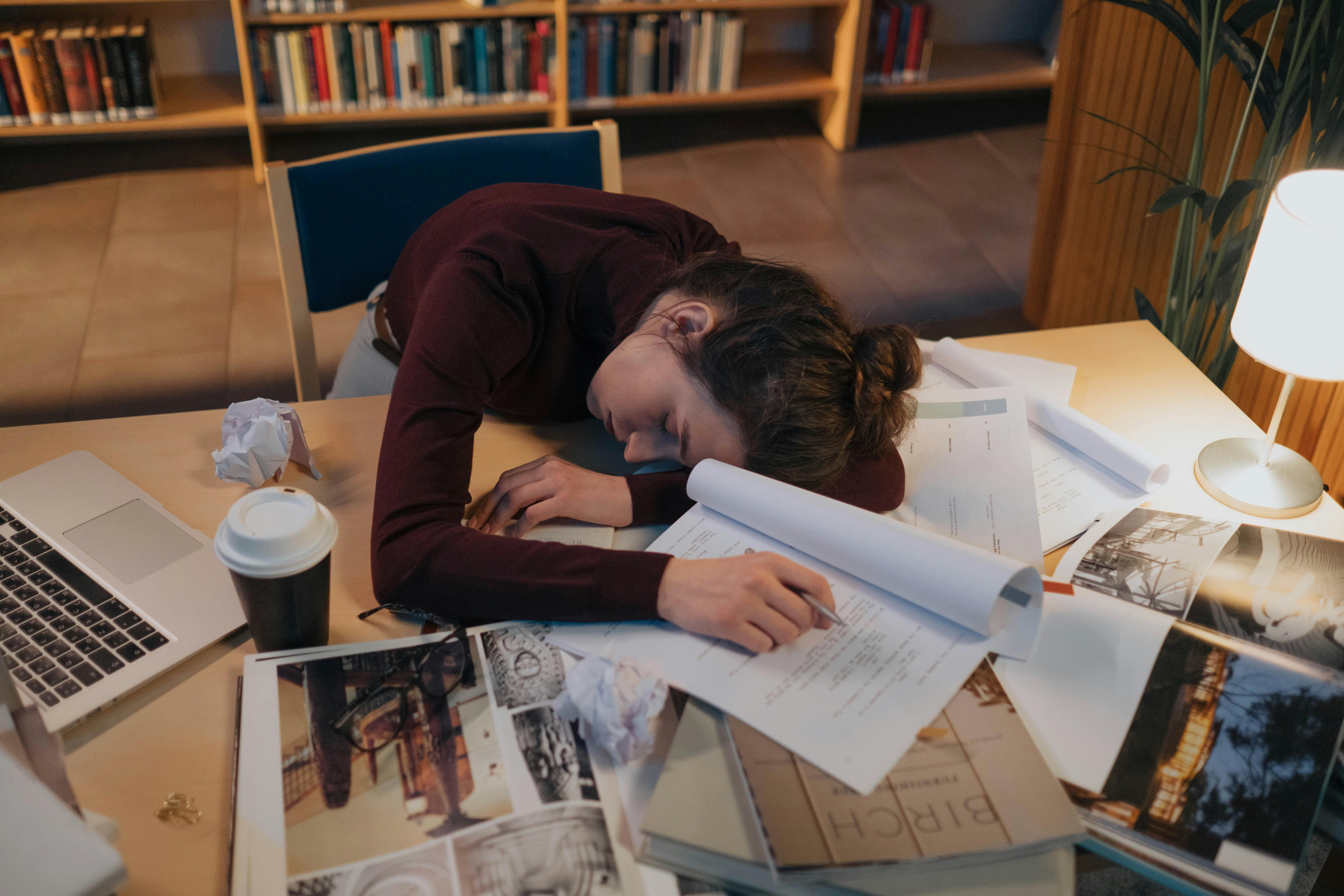 young woman falling asleep while studying