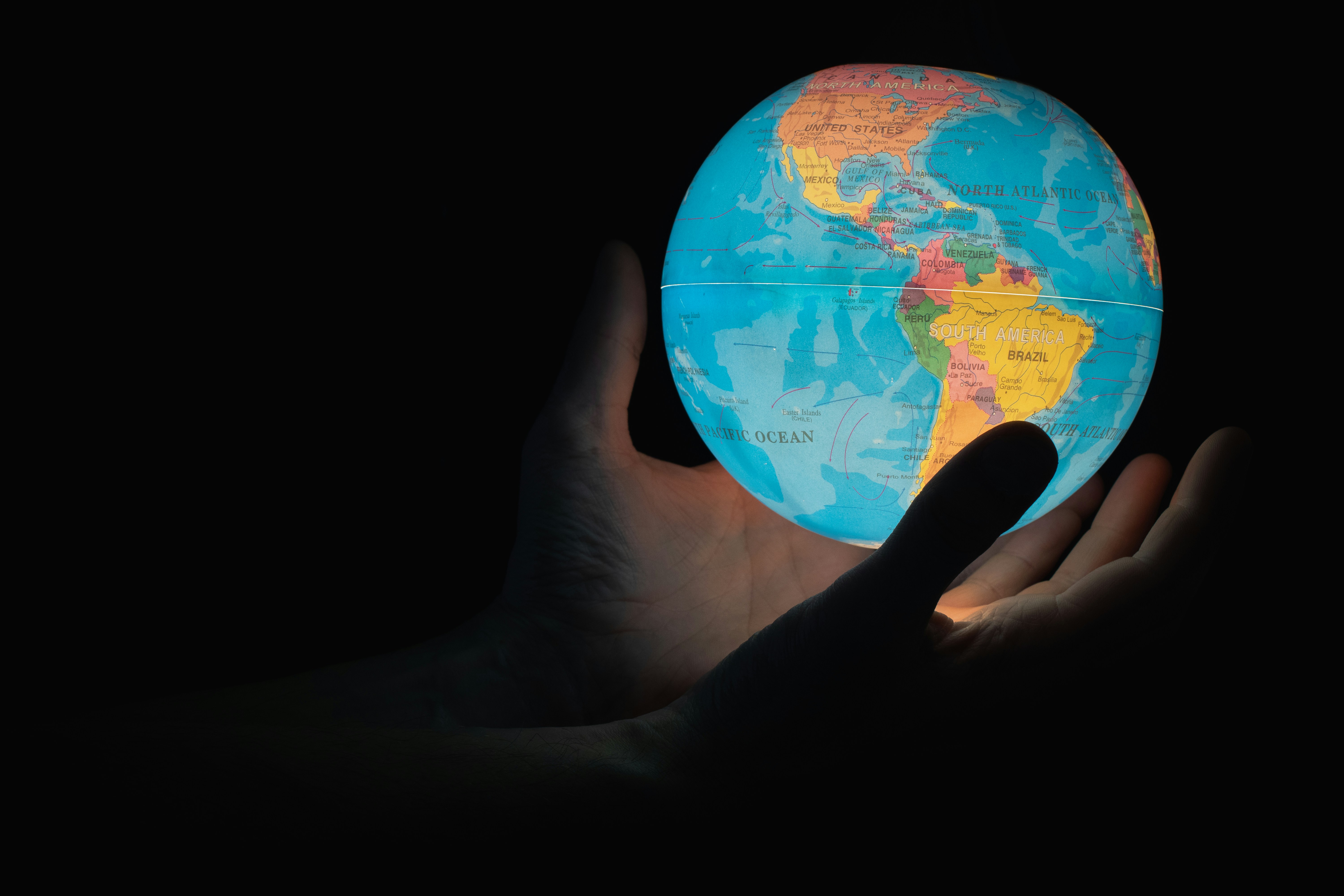 A light up globe held in two hands.